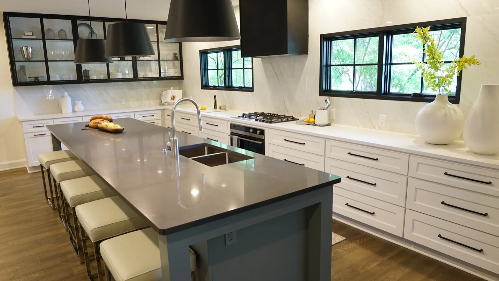 Remodeled kitchen with gray quartz island and black-framed windows